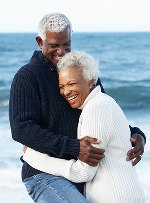 Romantic Senior black couple hugging on the beach