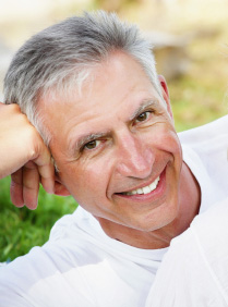 Older man resting his head on his fist and smiling