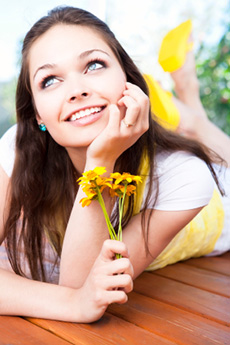 Woman holding some flowers with her hand resting on her jaw